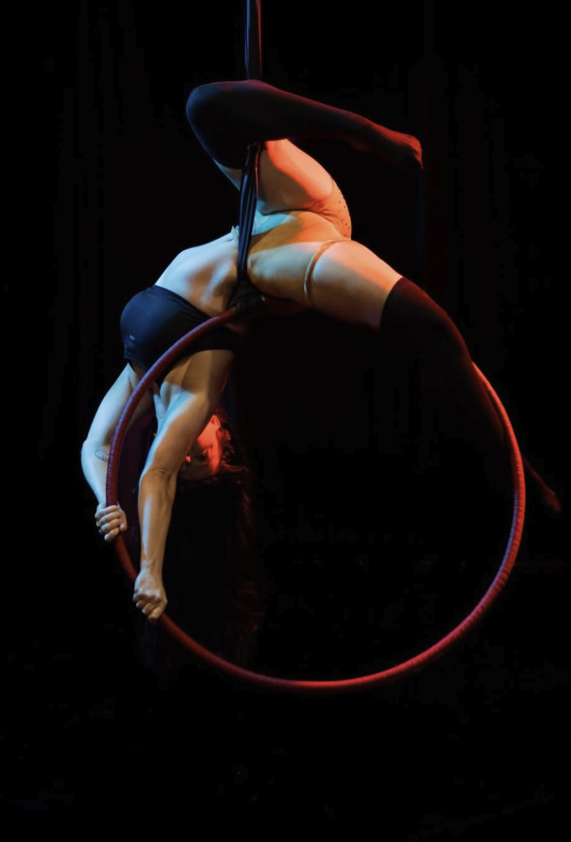 Aerialist suspended in high-speed artificial rain